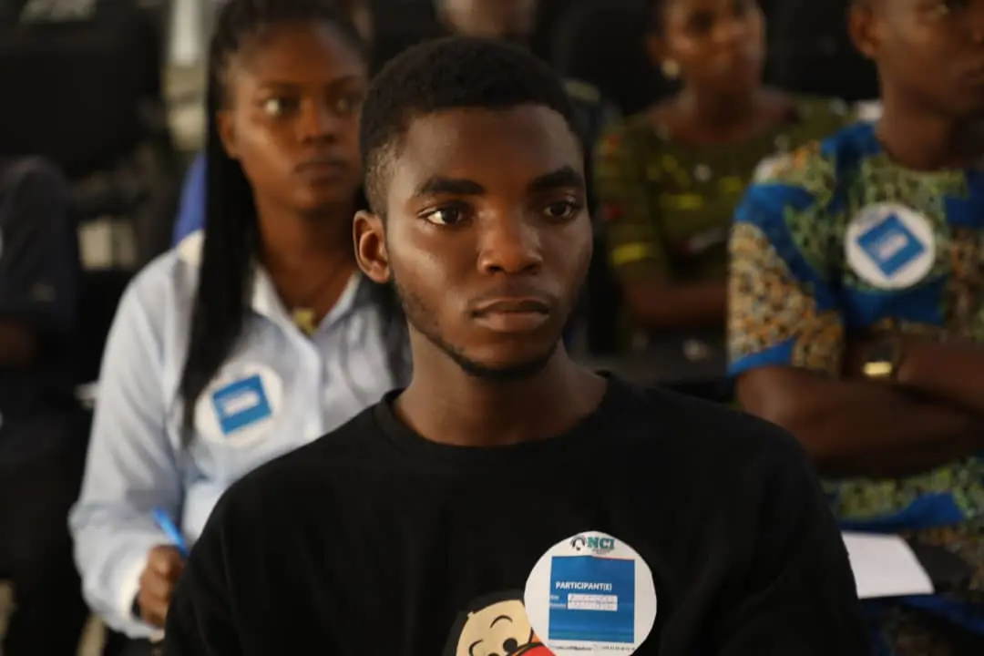 Portrait de Akintola, participant NCI, souriant.